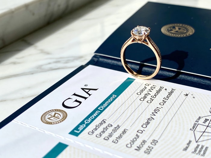 GIA lab-grown diamond grading certificate with engagement ring — Colour D, Clarity VVS1, Cut Excellent