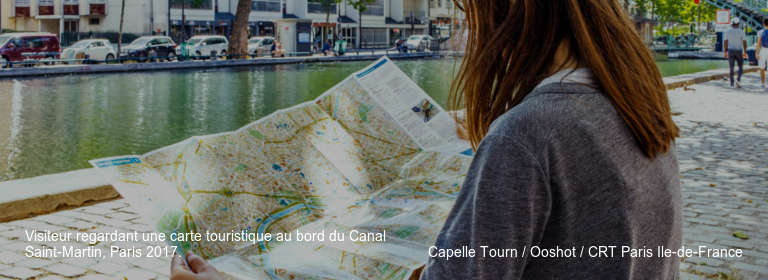 Visiteur regardant une carte touristique au bord du Canal Saint-Martin, Paris 2017.