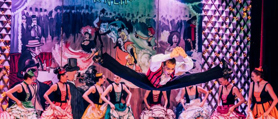 A male and female dancers performing a French Cancan on stage