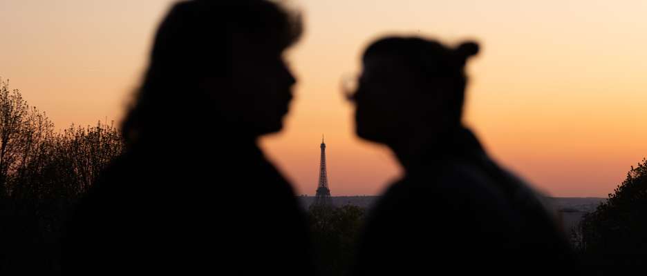 Shadow of two lovers at sunset with the Eiffel Tower between them