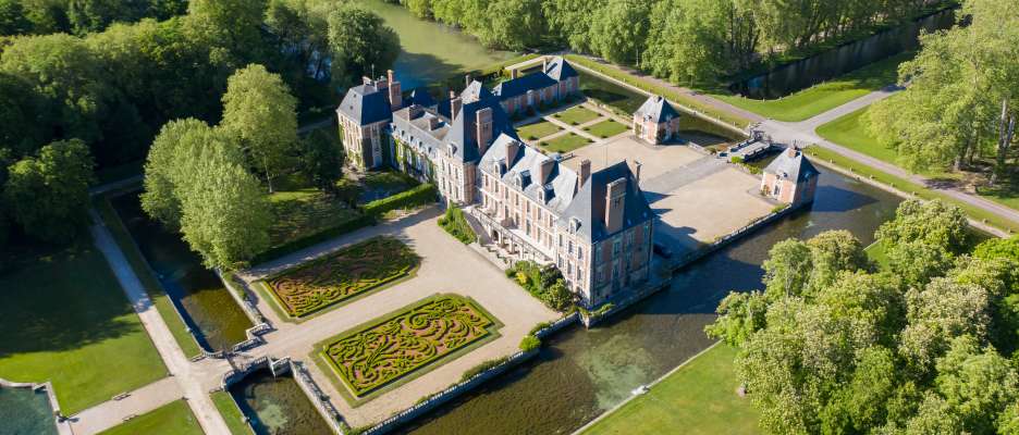 Aerial View Shot of Château de Courances. Drone aerial view with landscaped gardens.