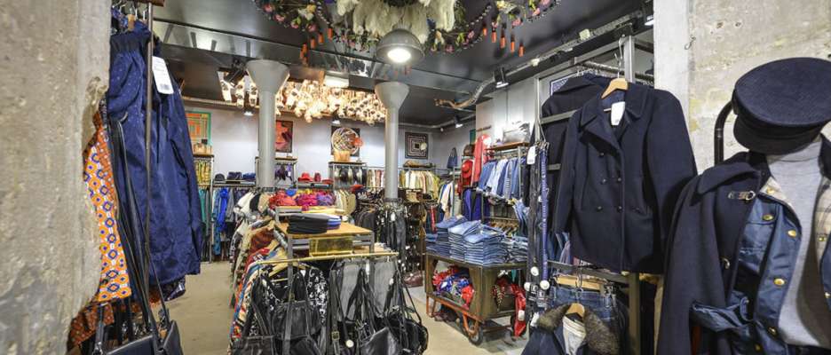 Intérieur de la friperie Kiliwatch avec sacs et vêtements de seconde main