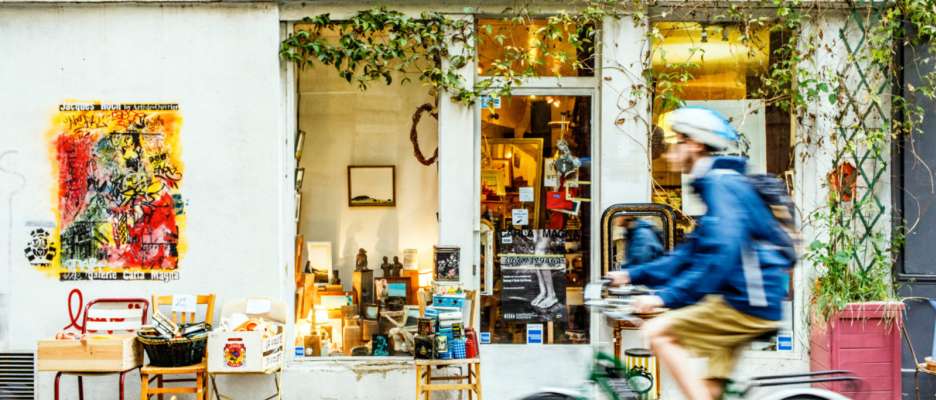 Visiteur à vélo devant une boutique du Village Saint-Paul, Paris 2017.