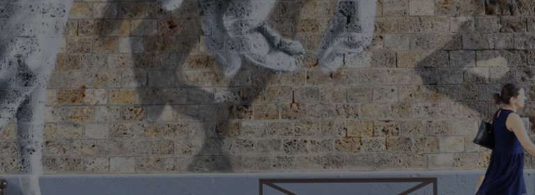 Femme passant devant une oeuvre Street Art de Oji, rue de l'Ourcq, Paris 2017.