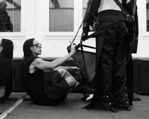 Photo noir et blanc du styliste Rick Owens ajustant un vêtement