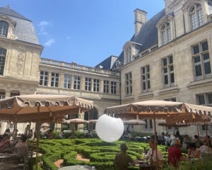 Des clients déjeunent dans le cadre paisible de la cour du musée Carnavalet, au restaurant JOLI.