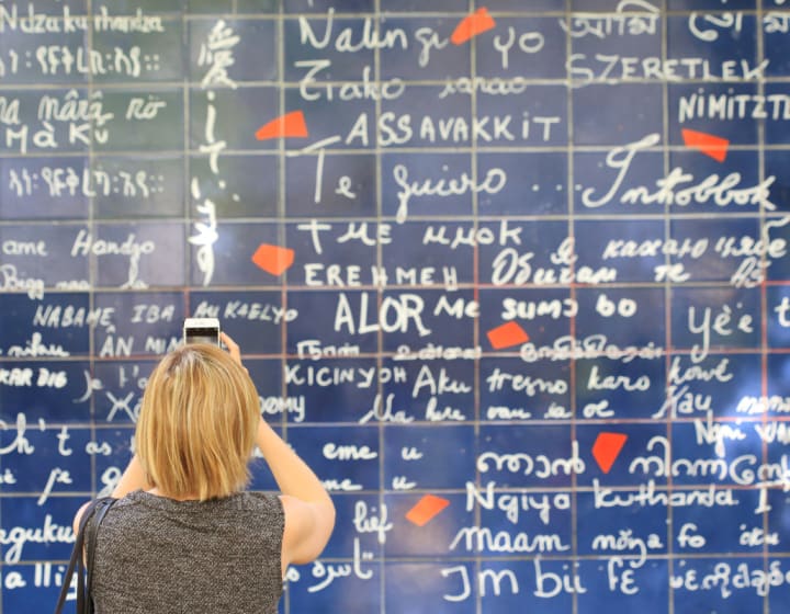 Femme photographiant le mur des Je t&#039;aime