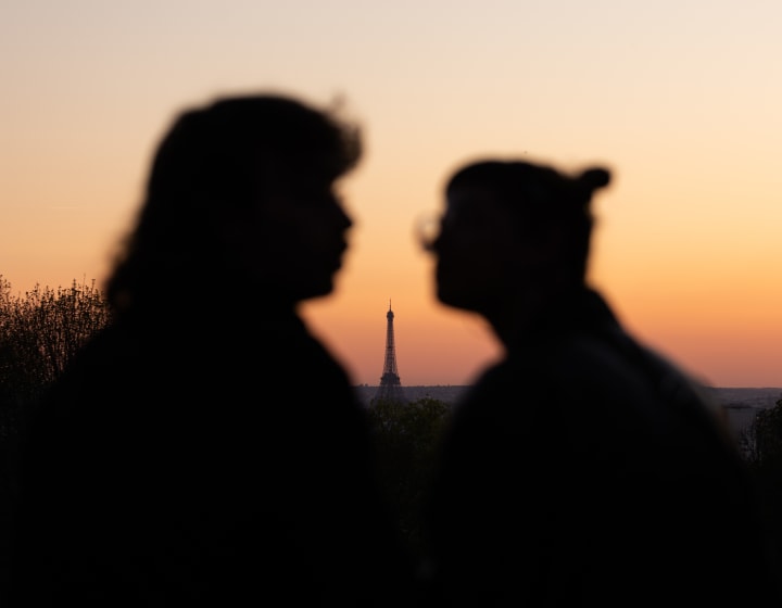 Shadow of two lovers at sunset with the Eiffel Tower between them