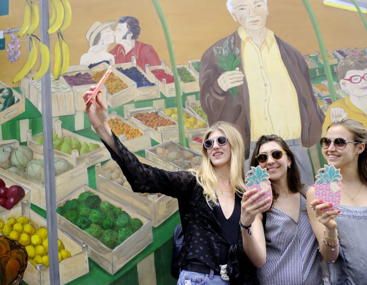 Amies se prenant en photo devant une fresque au Marché des Enfants Rouges