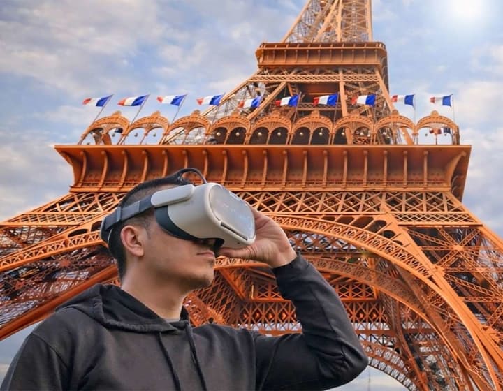 A man wearing a virtual reality headset in front of the Eiffel Tower