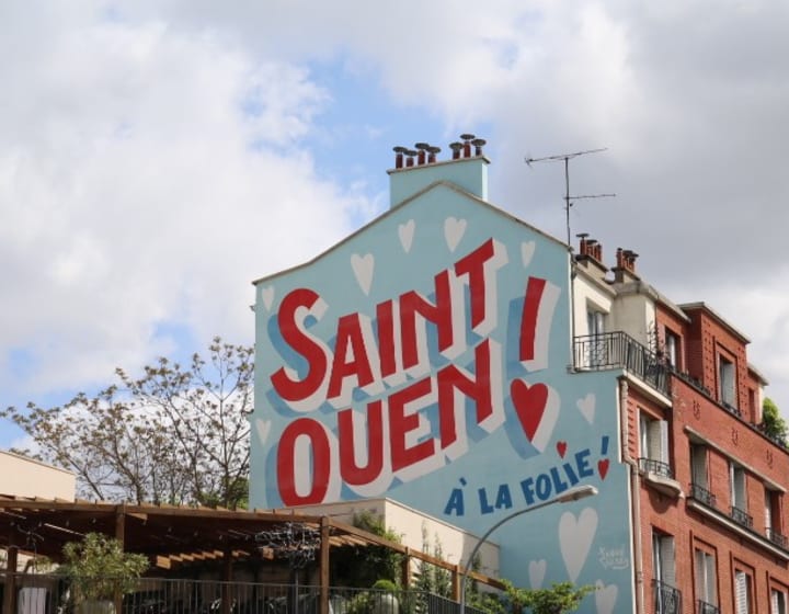 Immeuble peint aux couleurs de Saint-Ouen derrière le Bouillon du Coq
