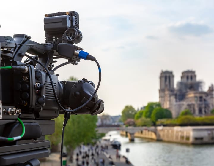 Filming camera in the foreground with Notre-Dame in the background
