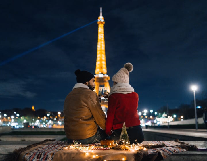 Couple célébrant la Saint-Valentin avec du champagne à l&#039;extérieur, la nuit devant la tour Eiffel