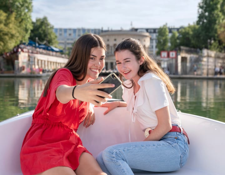 Deux filles se prenant en photo avec un smartphone sur un bateau