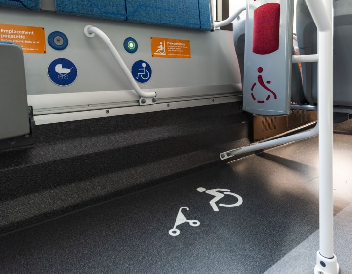 Signalétique et emplacement réservé aux pmr et poussette dans un bus parisien