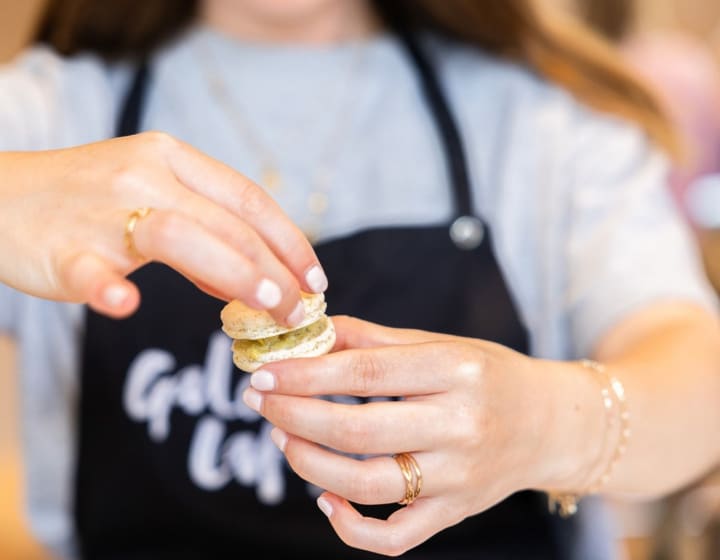 Femme montrant un macaron fait lors de l'atelier proposé aux Galeries Lafayette