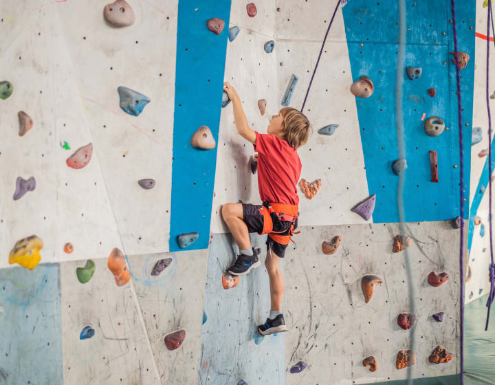 Young boy climbing on a climbing wall