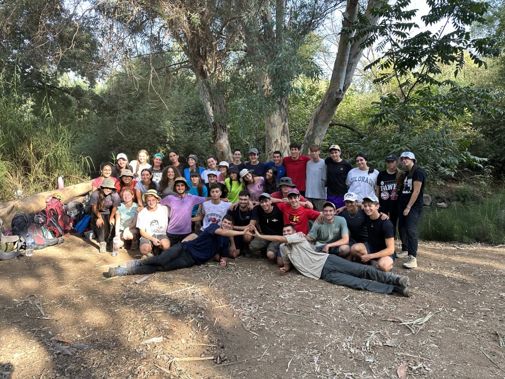 Whole mechina taking a picture outdoors.