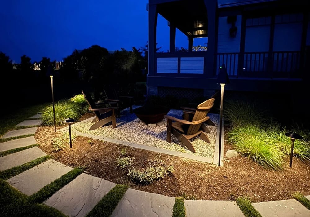 Firepit and surrounding landscape illuminated for outdoor entertaining