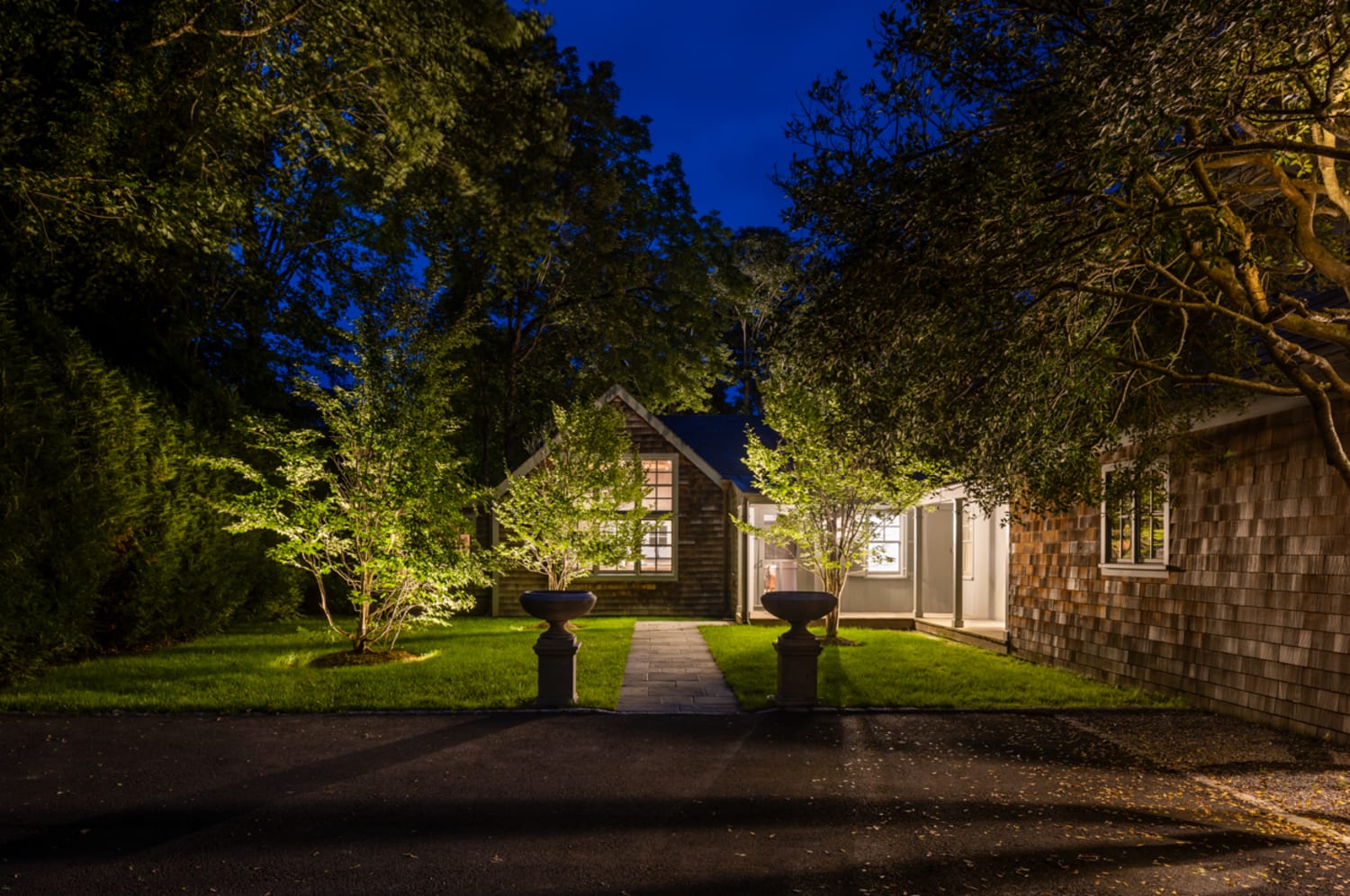 Sculpture and garden illuminated by landscape lighting in the Hamptons