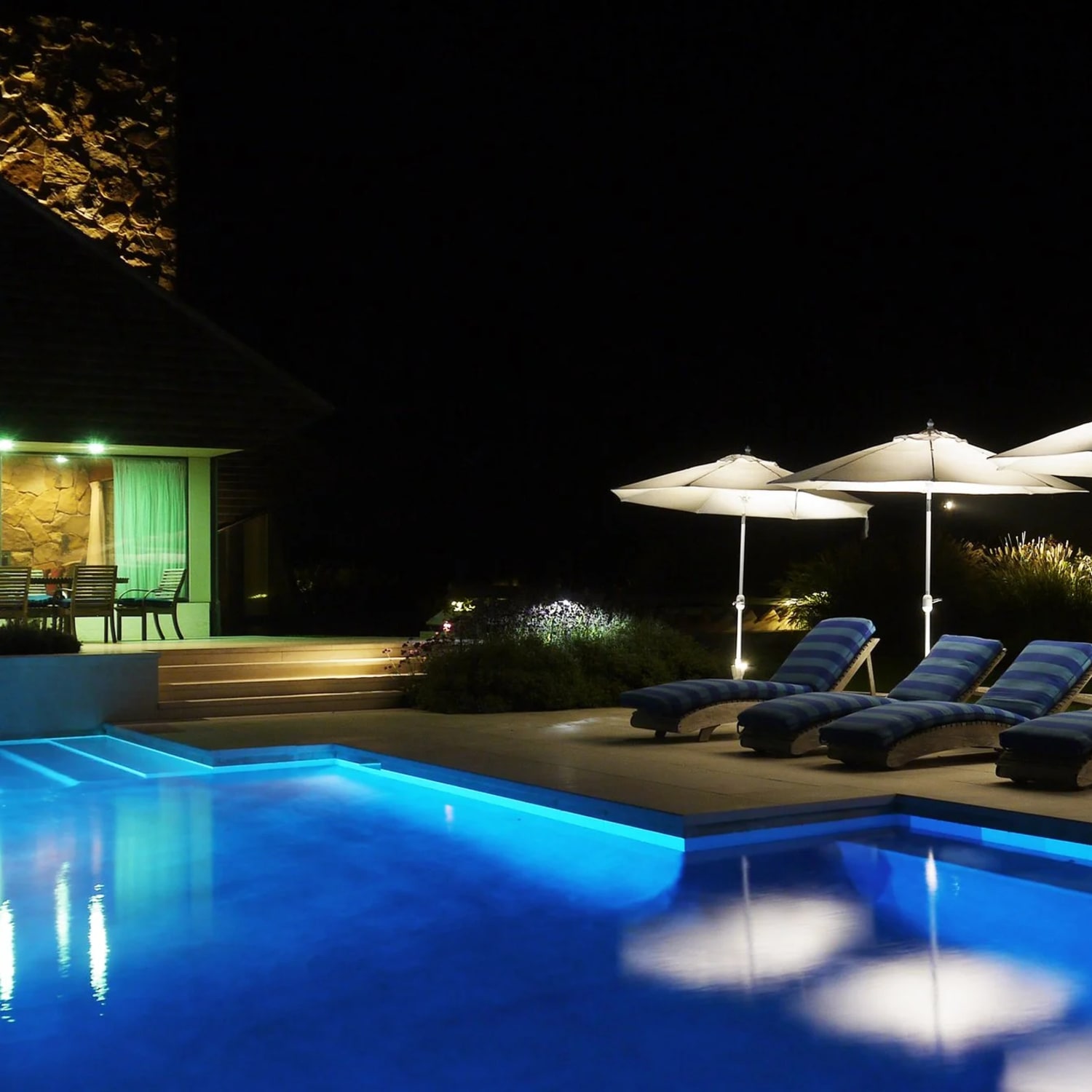 Poolside Hamptons home with warm architectural and landscape lighting