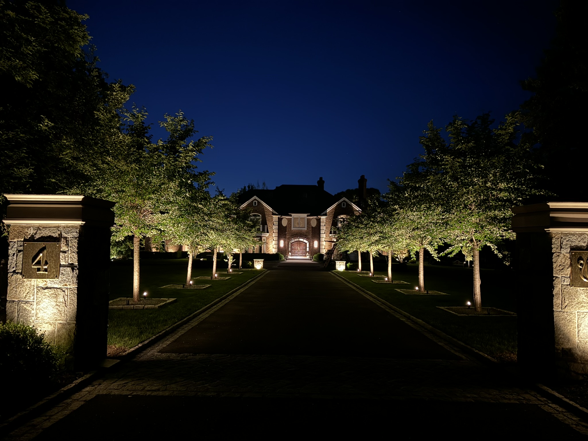Outdoor lighting for a Hamptons home with warm pathway and garden illumination