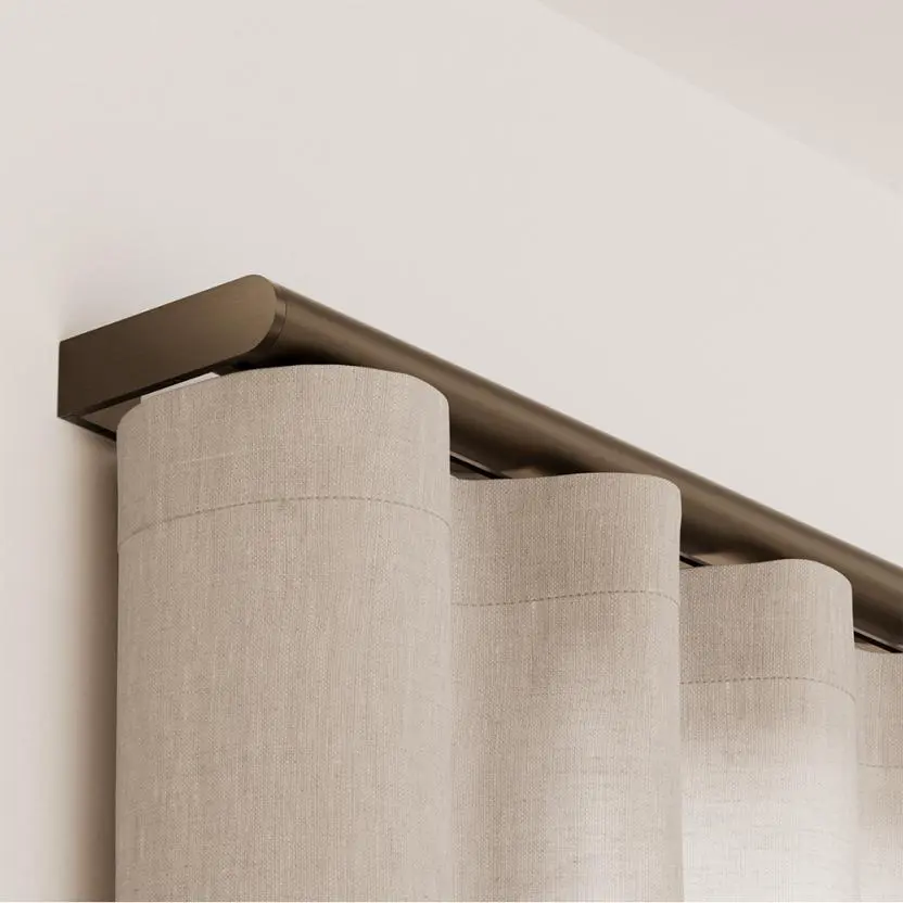 Close detail of Palladiom Drapery's bronze-toned exposed track above ripple-fold drapery