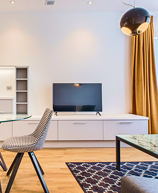 A well-furnished living room showcasing a table, chairs, and a TV, ideal for entertainment and social gatherings.