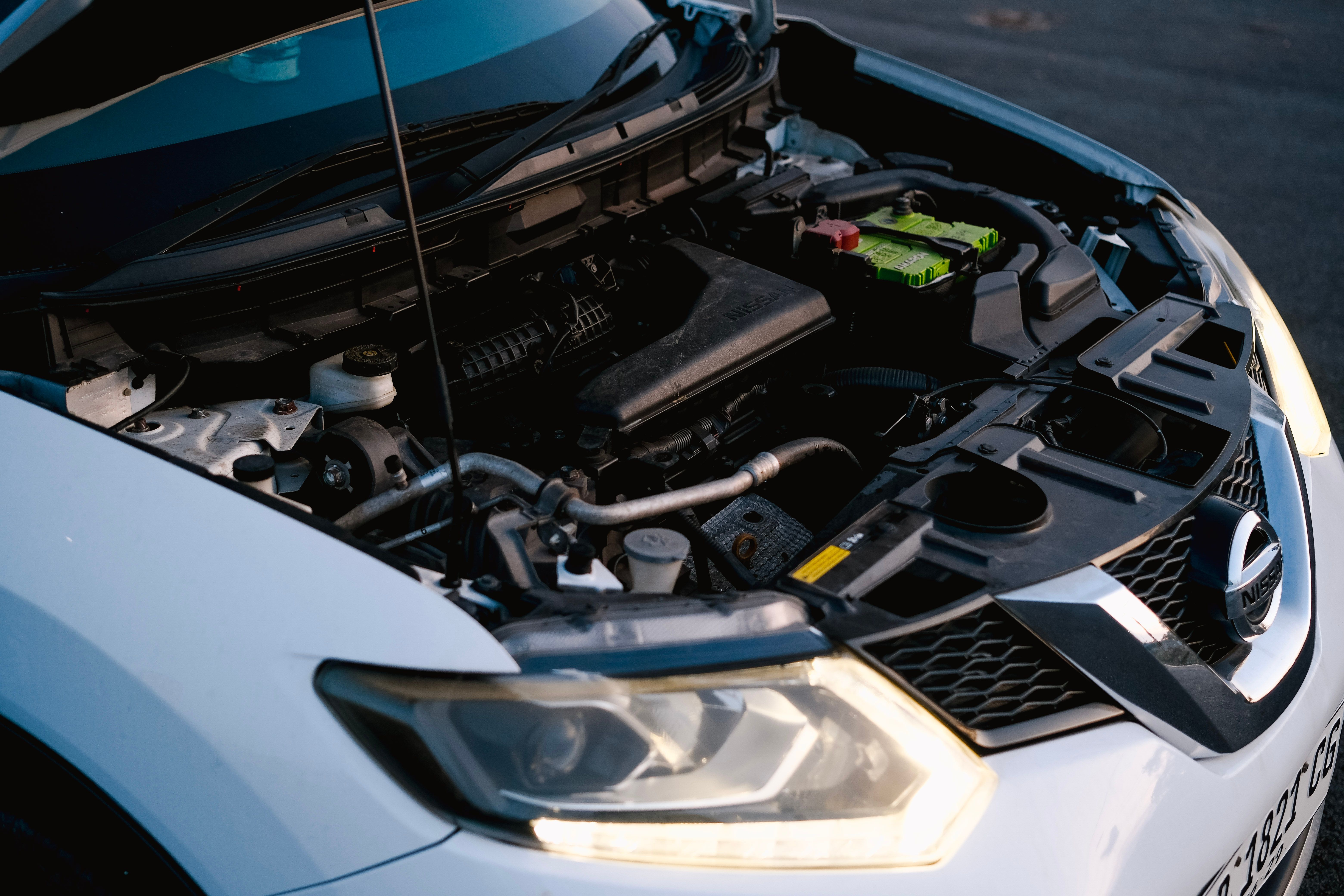 mechanic installing car battery under hood