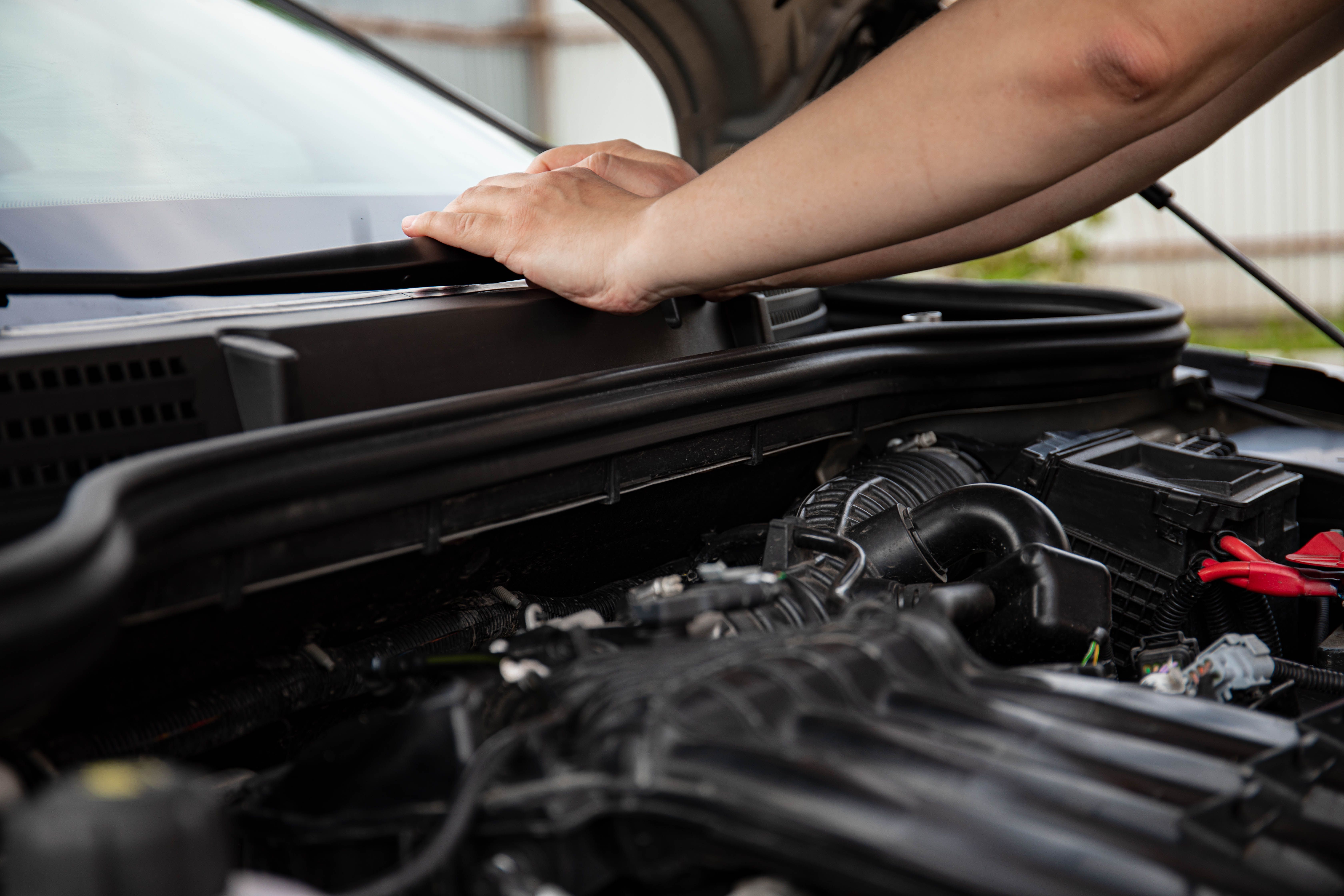 mechanic replacing car battery outdoors