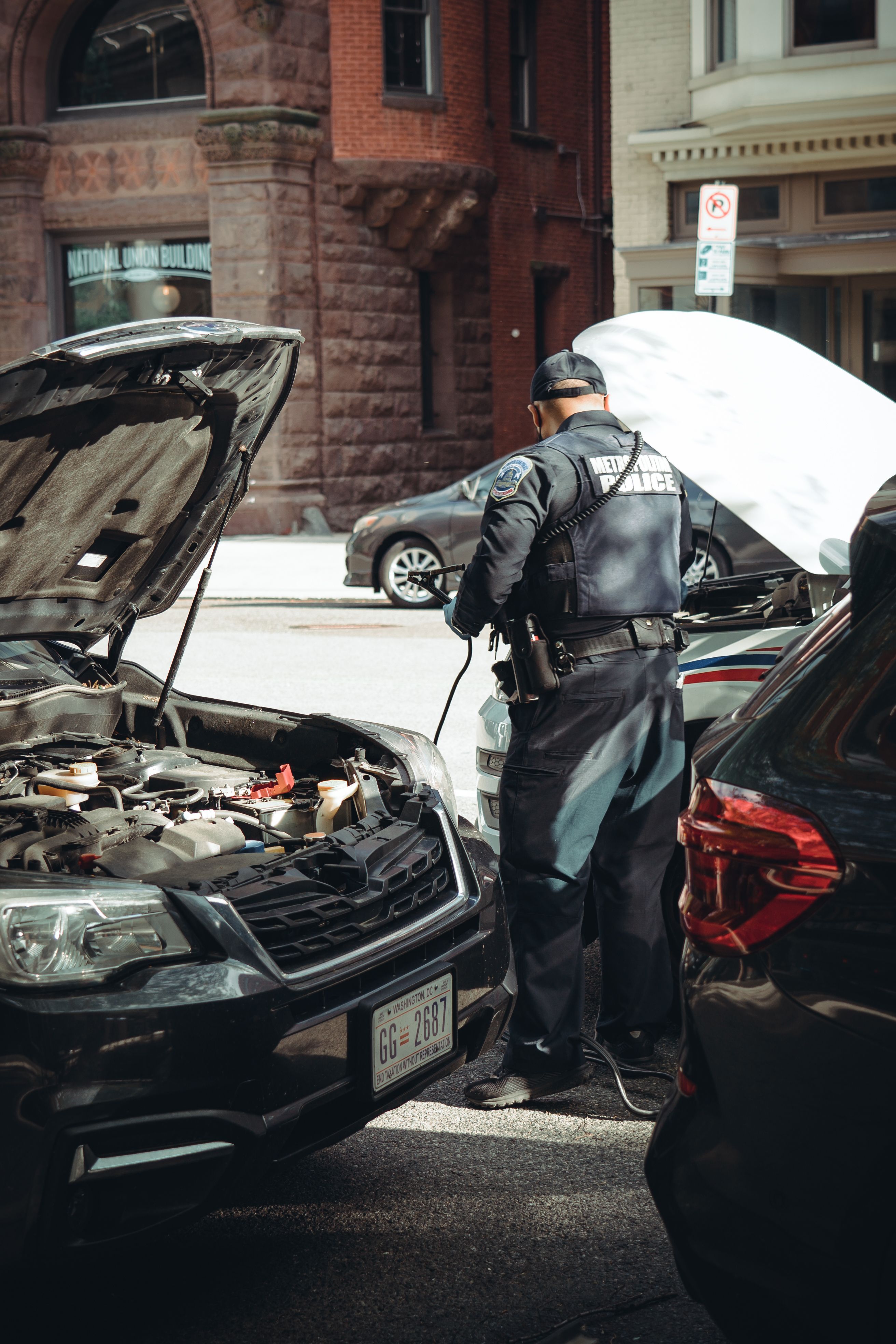 mechanic jump starting car battery outdoors