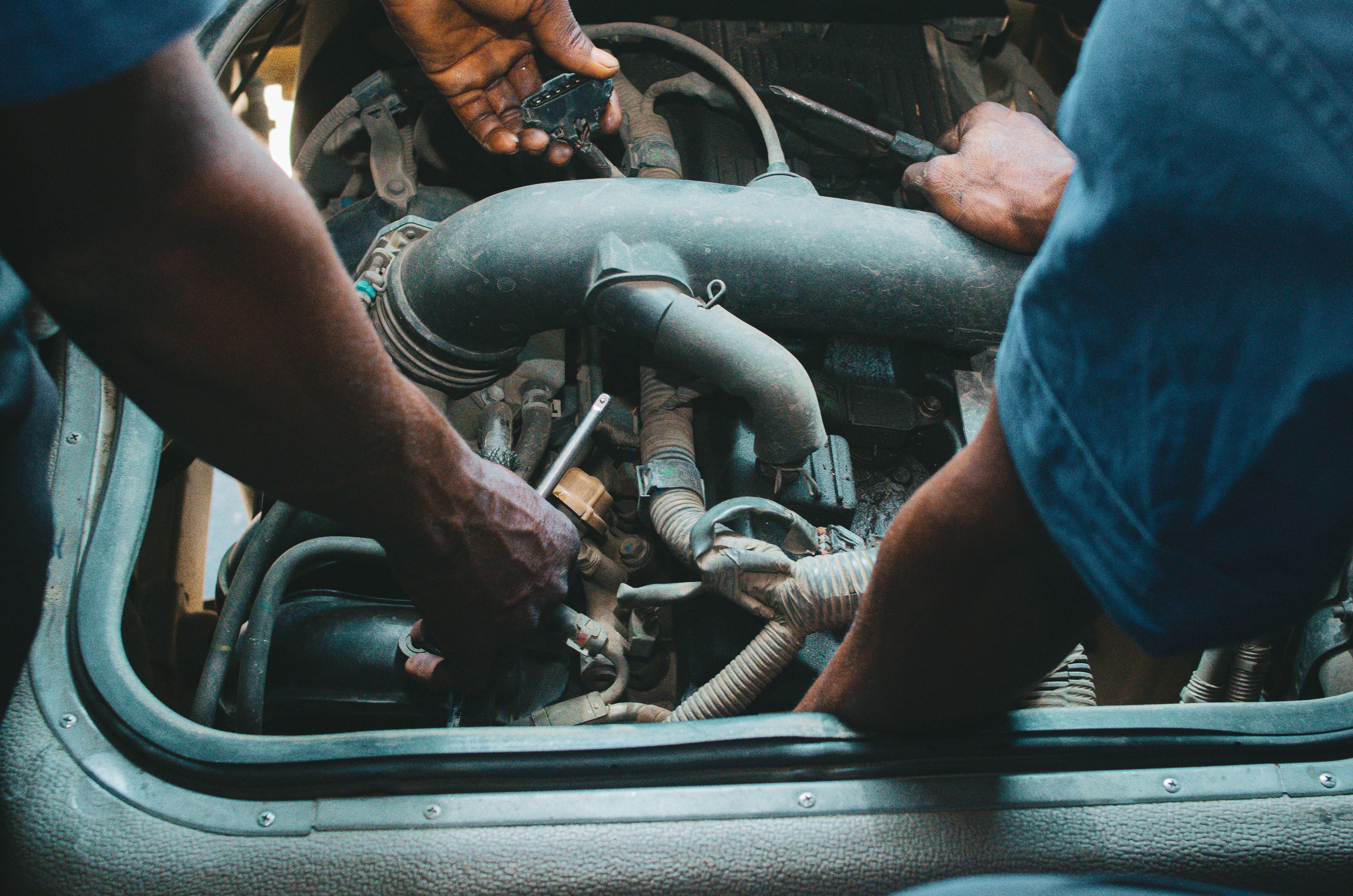 mechanic replacing starter motor car engine