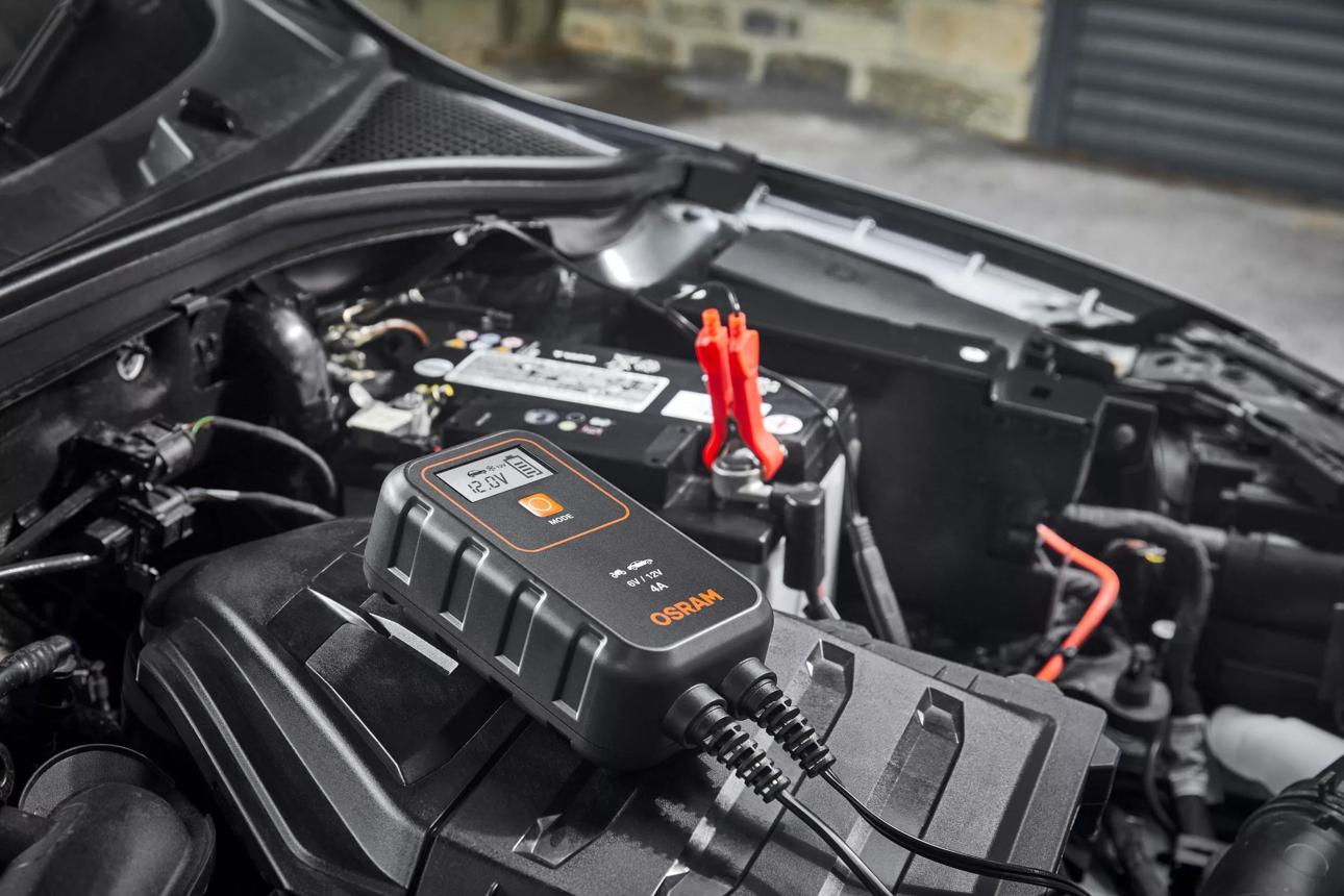 Car battery connected to a suitable smart charger during a controlled battery recharge