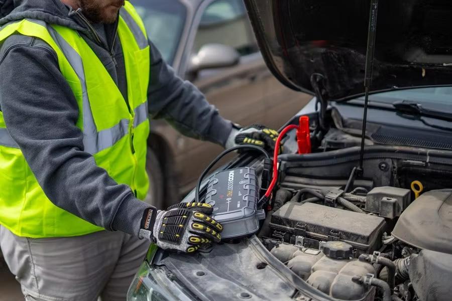 Technician preparing suitable battery assistance equipment for a car that will not start.