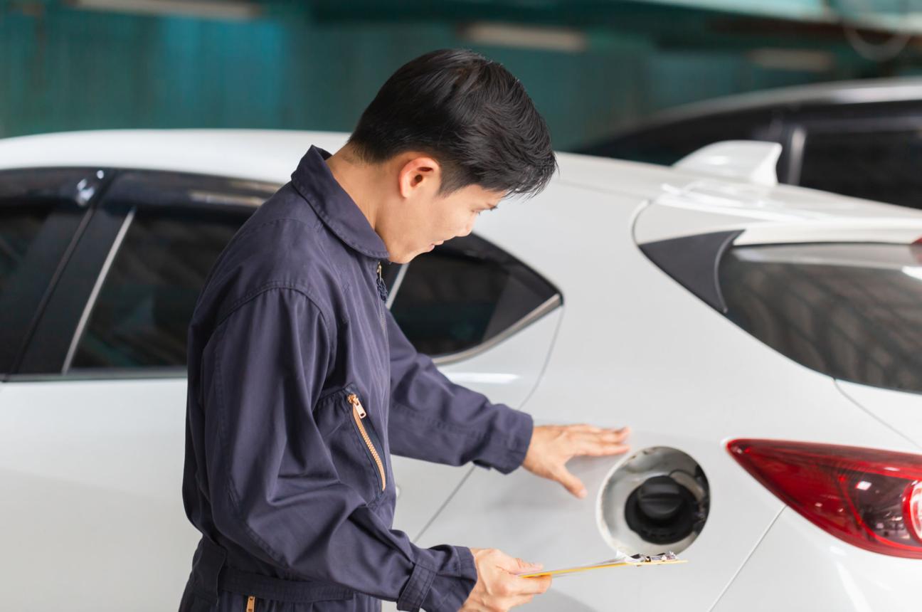 mechanic inspecting vehicle fuel filler