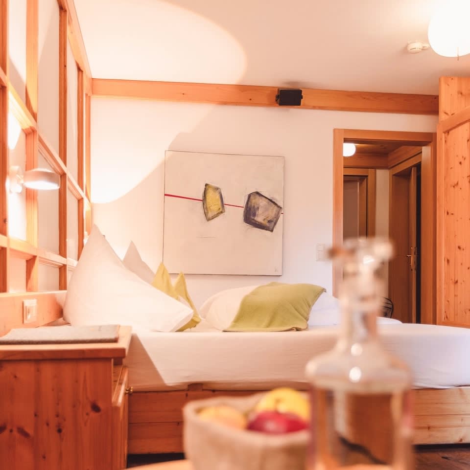 A cozy room at the Glemmtalerhof in Hinterglemm with wooden accents and modern art. Fresh fruits are visible.