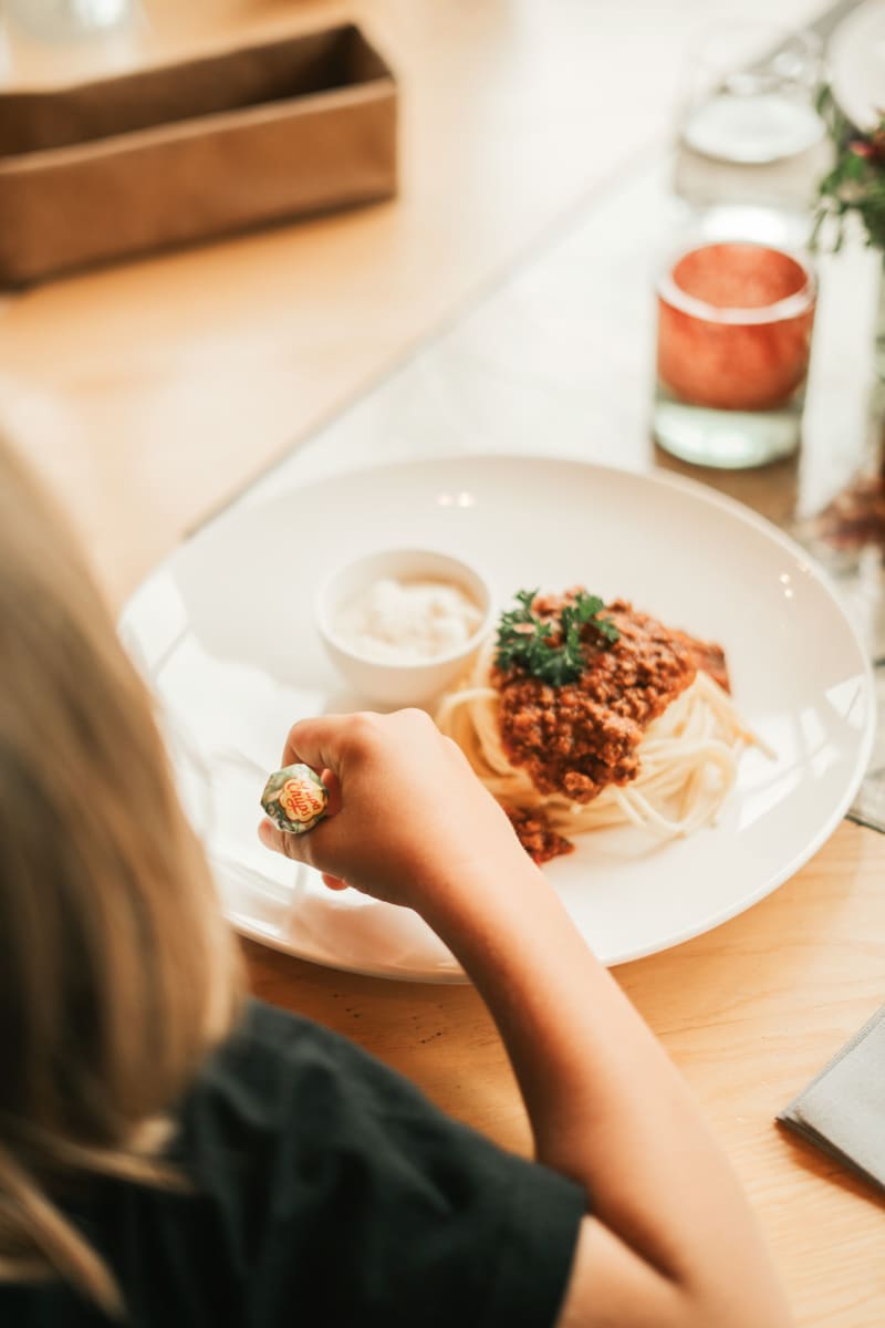 Ein Kind isst Spaghetti mit Bolognese im Glemmtalerhof in Hinterglemm.