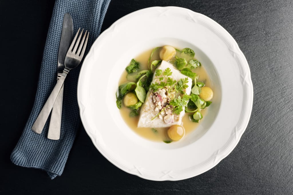 A plated west-coast halibut dish with greens