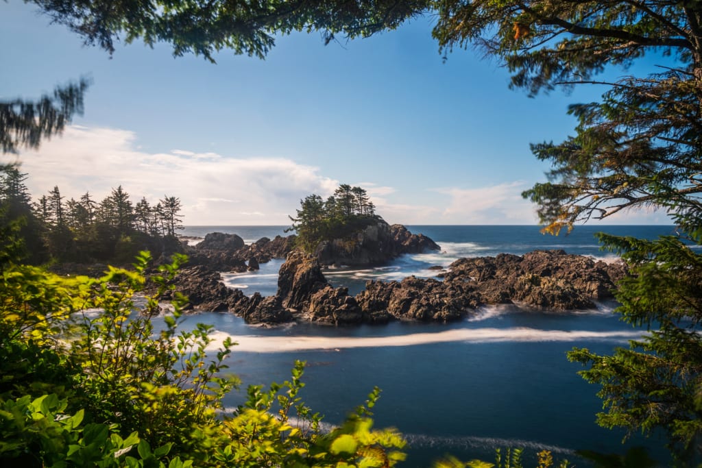 Rugged rocky islets and surf framed by rainforest on the Wild Pacific Trail
