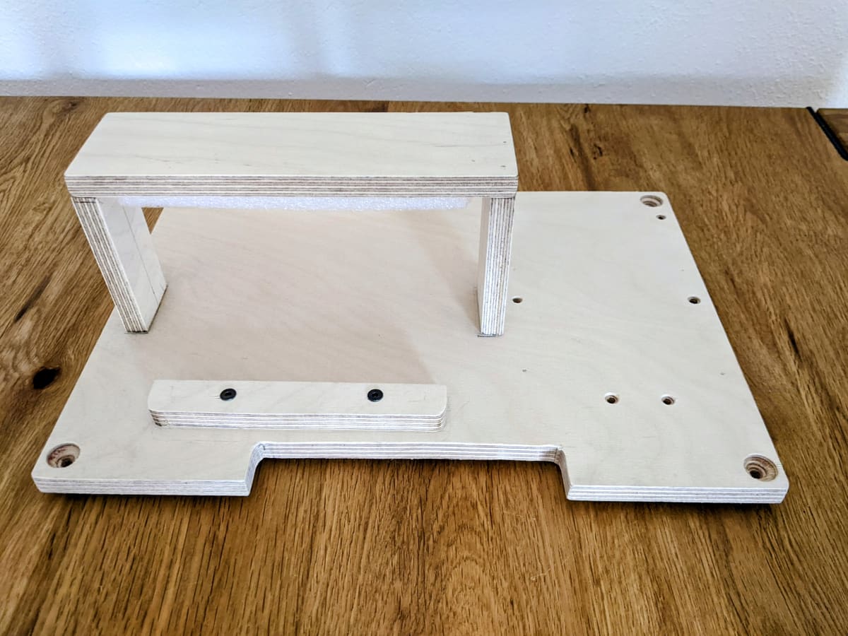 Plywood base plate with U-shaped bracket to hold the battery in place.
