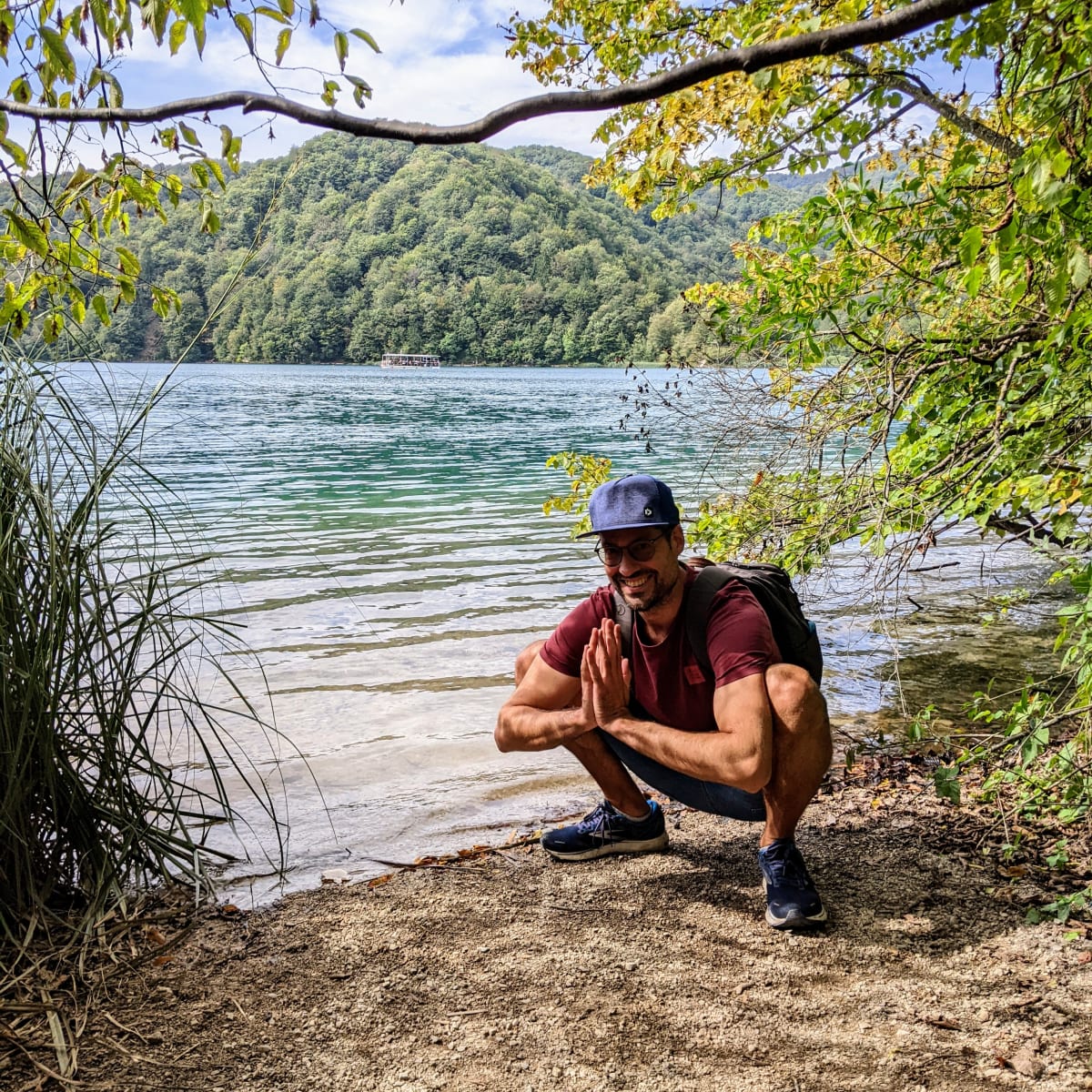 Fred in einer Yogapose am Ufer – im Hintergrund eines der Boote.