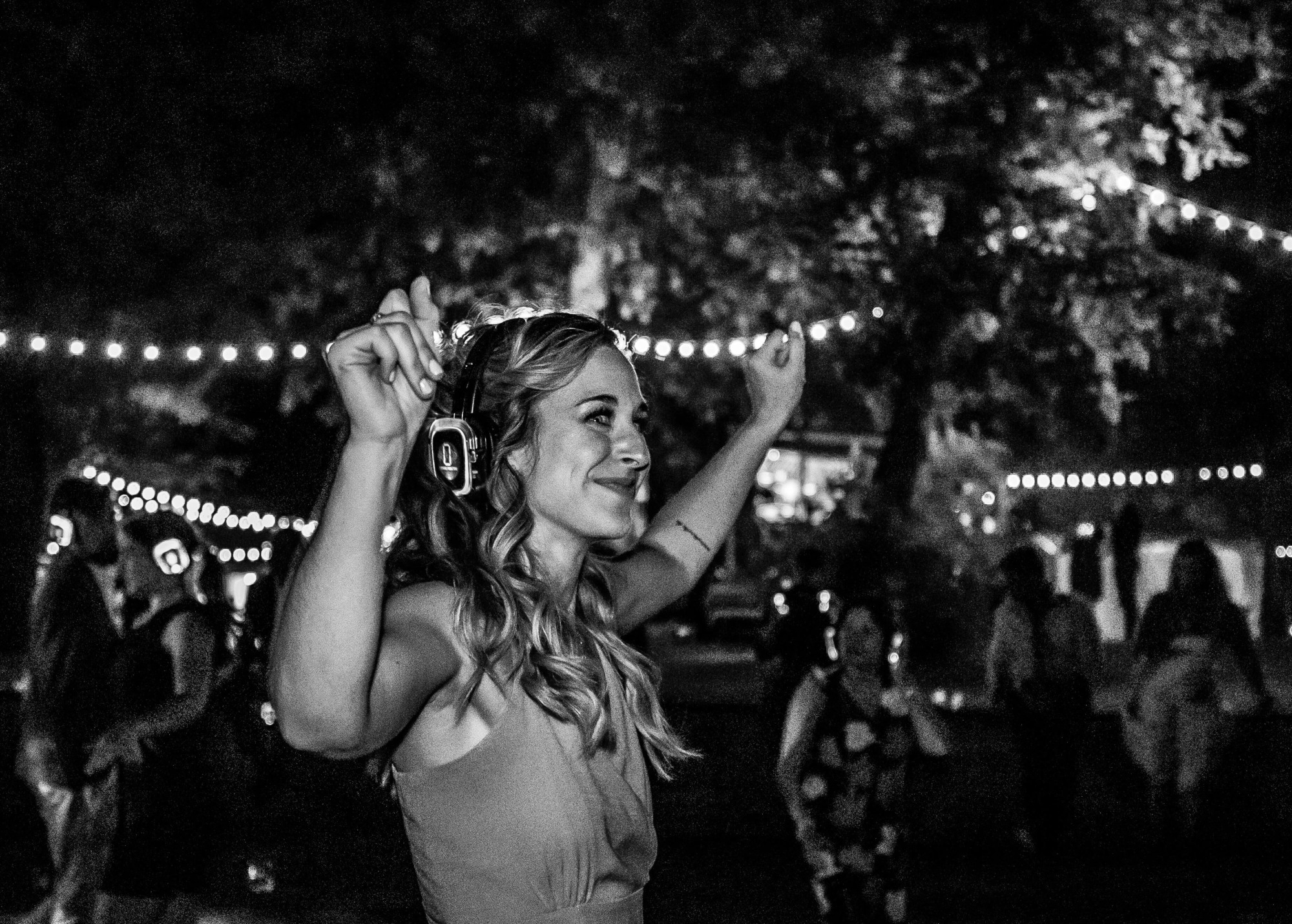 Black and white photo of women smiling while dancing with silent disco.