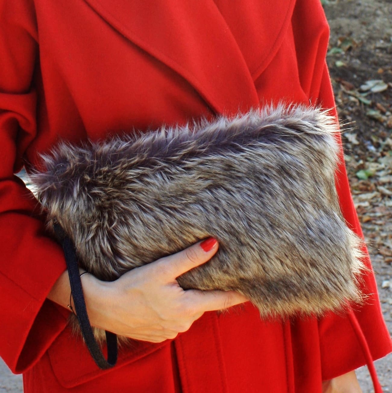 Pochette en fausse fourrure renard argenté avec dragonne amovible.