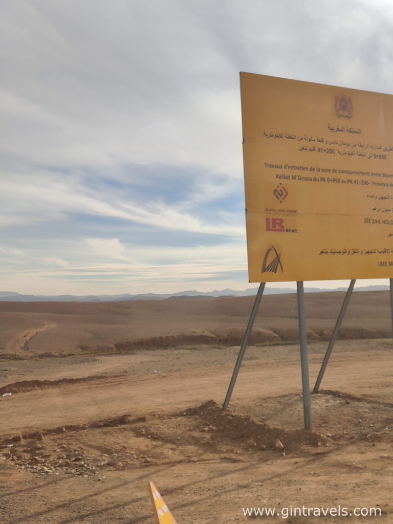 Trash by the sign when approaching Merzounga, Trash in Morocco