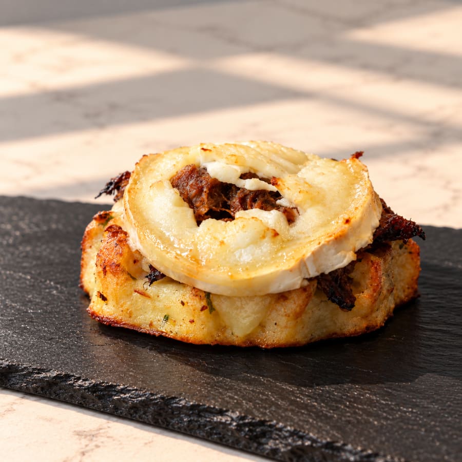 Gofre cruixent de patata coronat amb pulled pork melós i medalló de formatge de cabra fos a Ca la Gilda