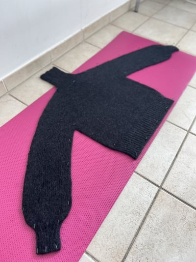 The sweater being blocked on a yoga mat