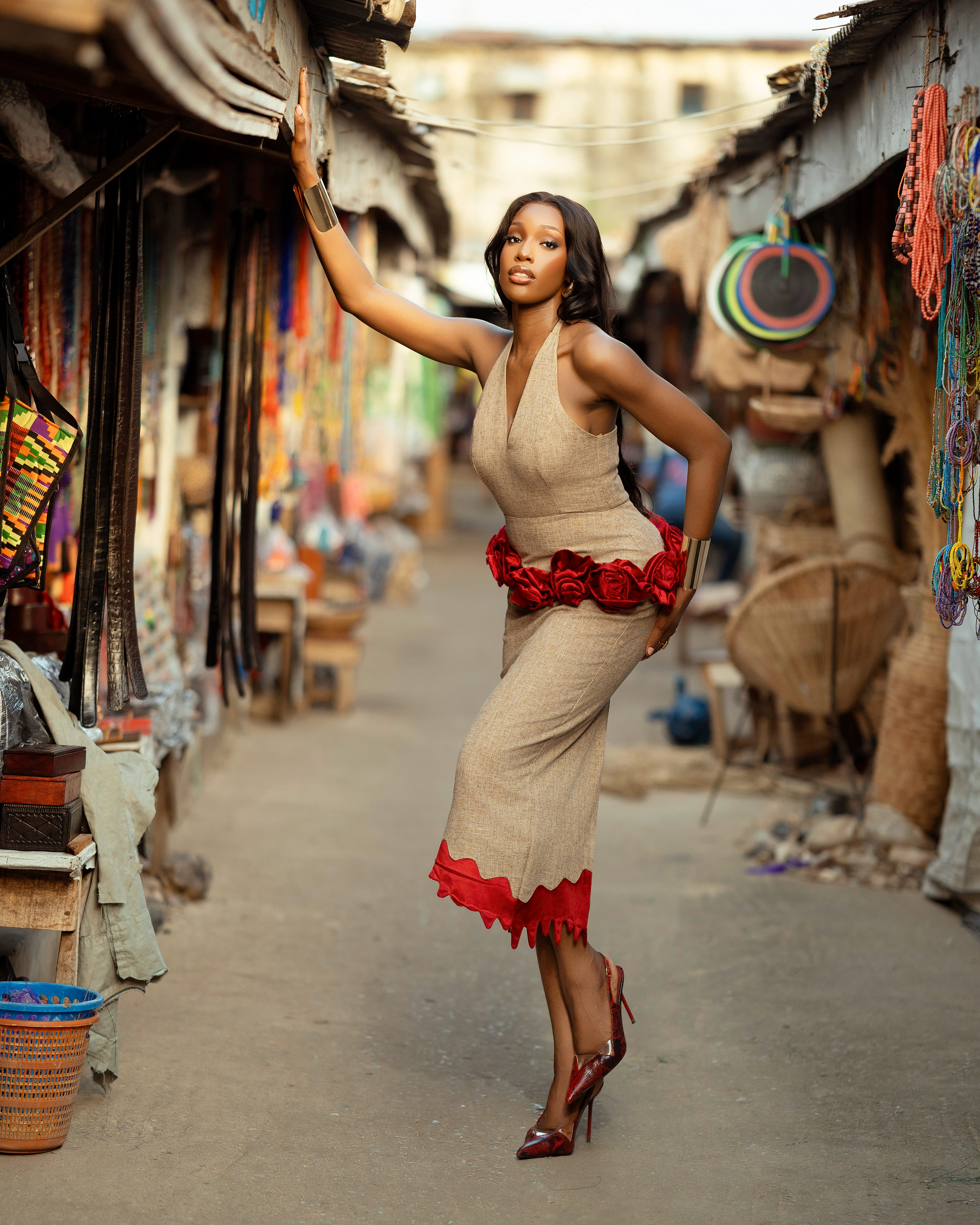 Model in red patterned blouse with beige skirt
