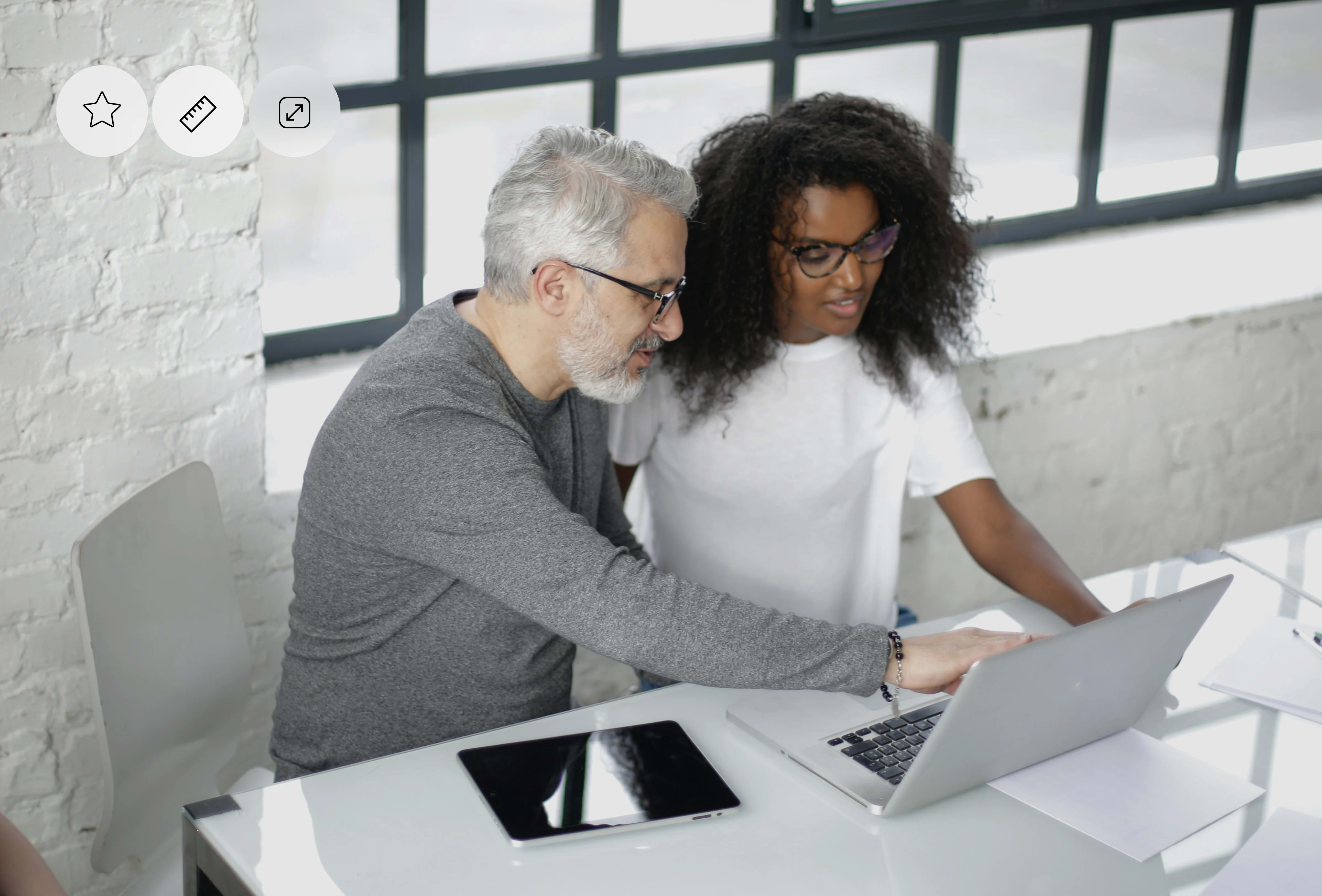 A person wearing glasses working on a laptop, representing software, design, or startup tasks.