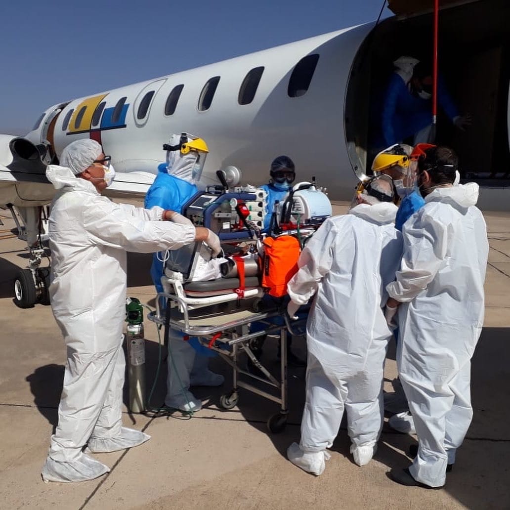 Equipo médico cargando paciente en avión sanitario