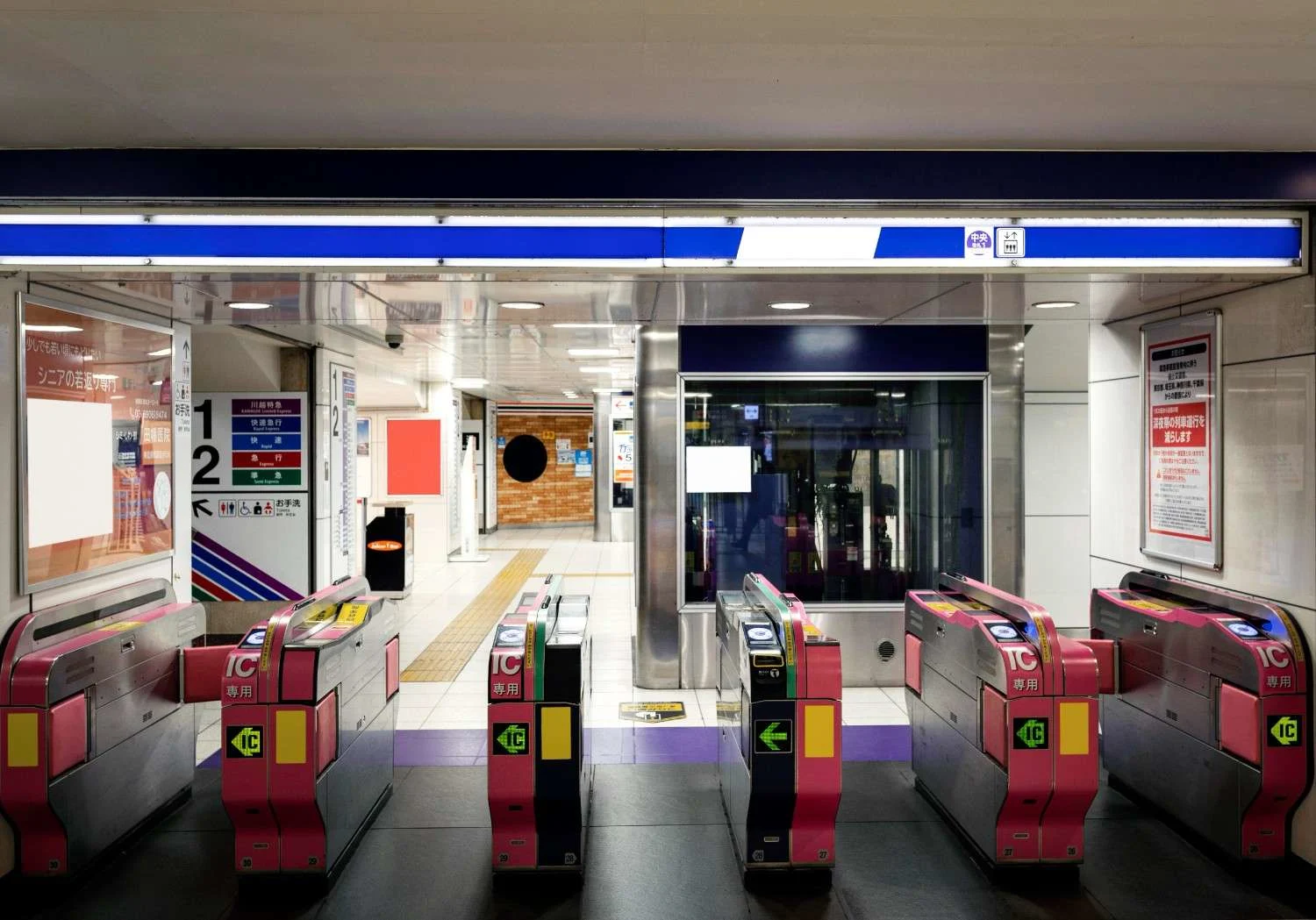 Automated subway ticket gates with IC card readers in a modern station, showing entry arrows and organized passenger access lanes.